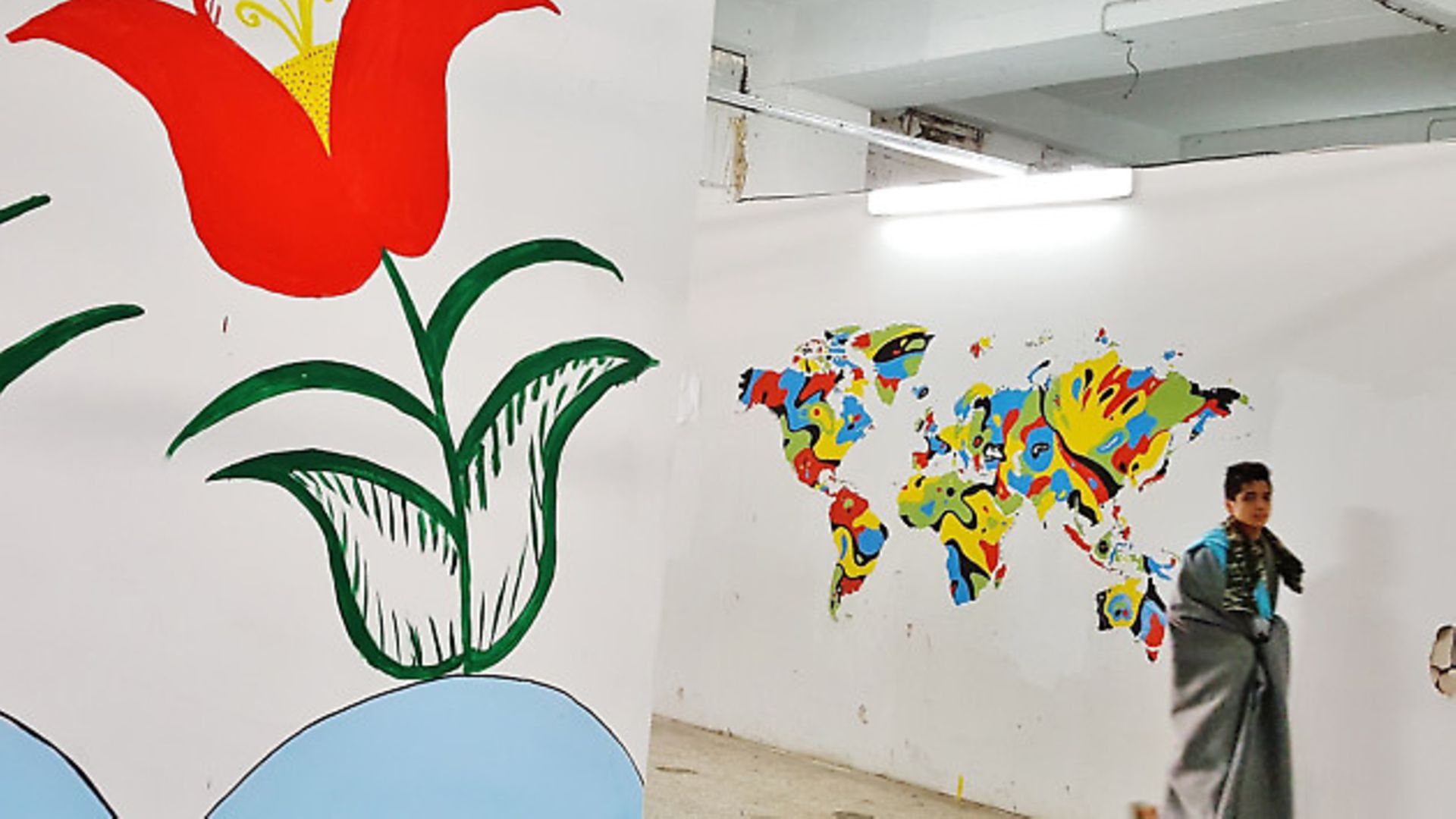 The flower on the left was the first mural to appear painted by an Afghan woman who refused to be photographed. It was much admired by the other refugees and inspired others to have a go. (Daniel Soll�) - Credit: Archant