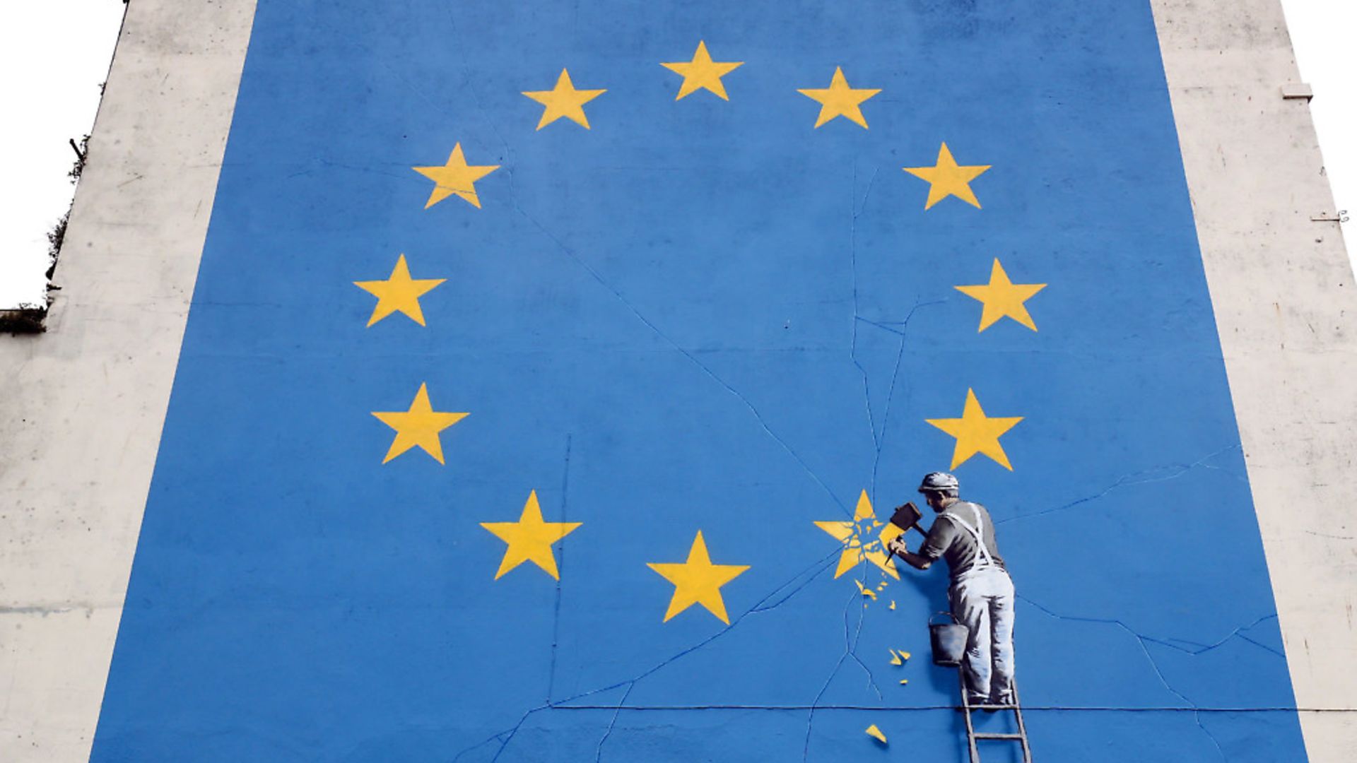 A view of a mural by artist Banksy of a workman removing a star from the EU flag which appeared yesterday near the ferry terminal in Dover, Kent. - Credit: PA Wire/PA Images