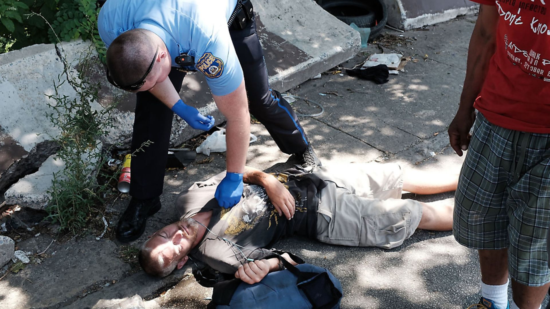 A police officer in Philadelphia tries to revive a man who has overdosed. Photo: Spencer Platt/Getty Images - Credit: Getty Images