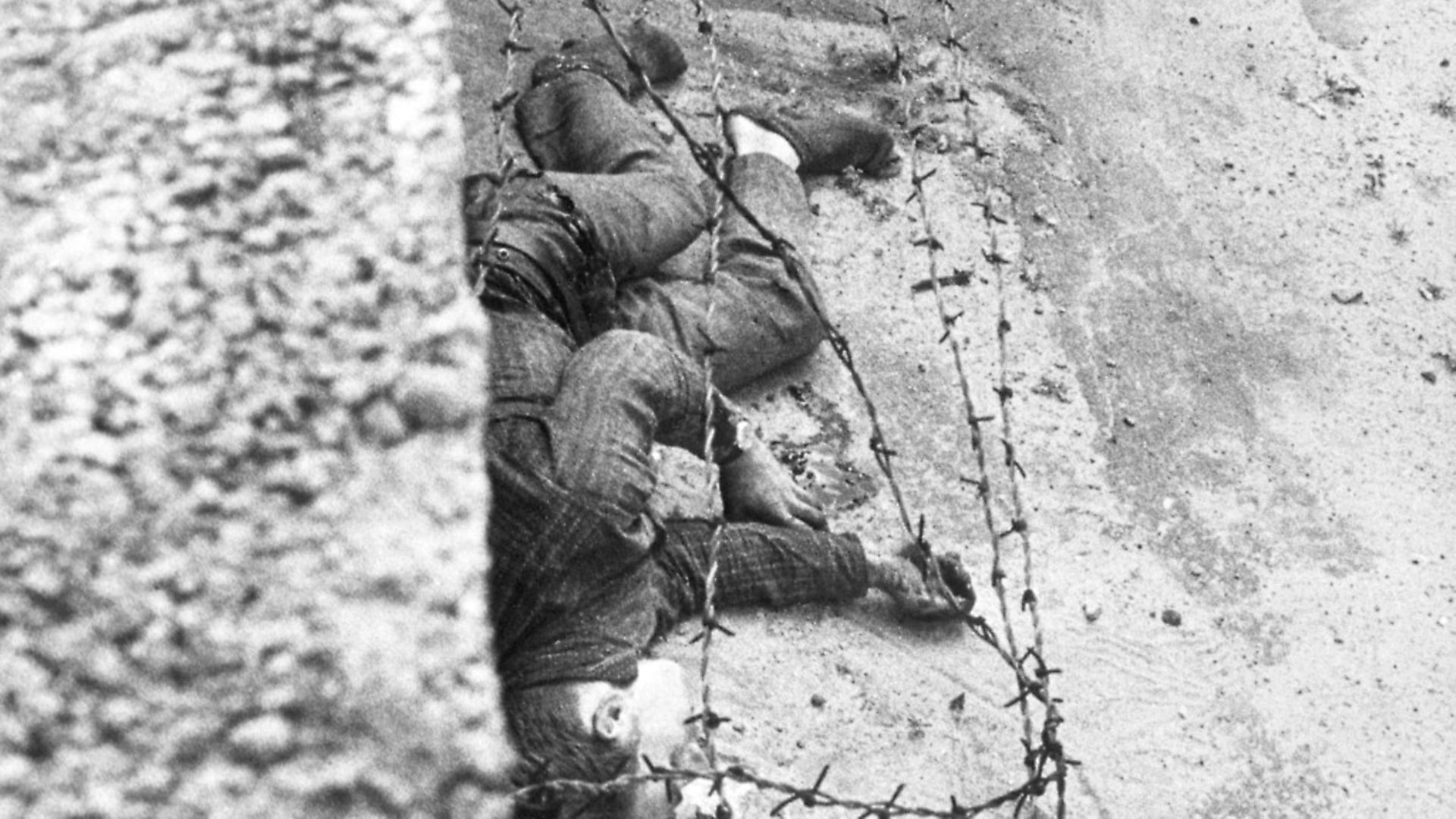 East Berliner Peter Fechter, 18, lies dying on the Eastern side of the Wall after he was shot by border guards while attempting to escape to West Berlin. Photo: Bettmann. - Credit: Bettmann Archive