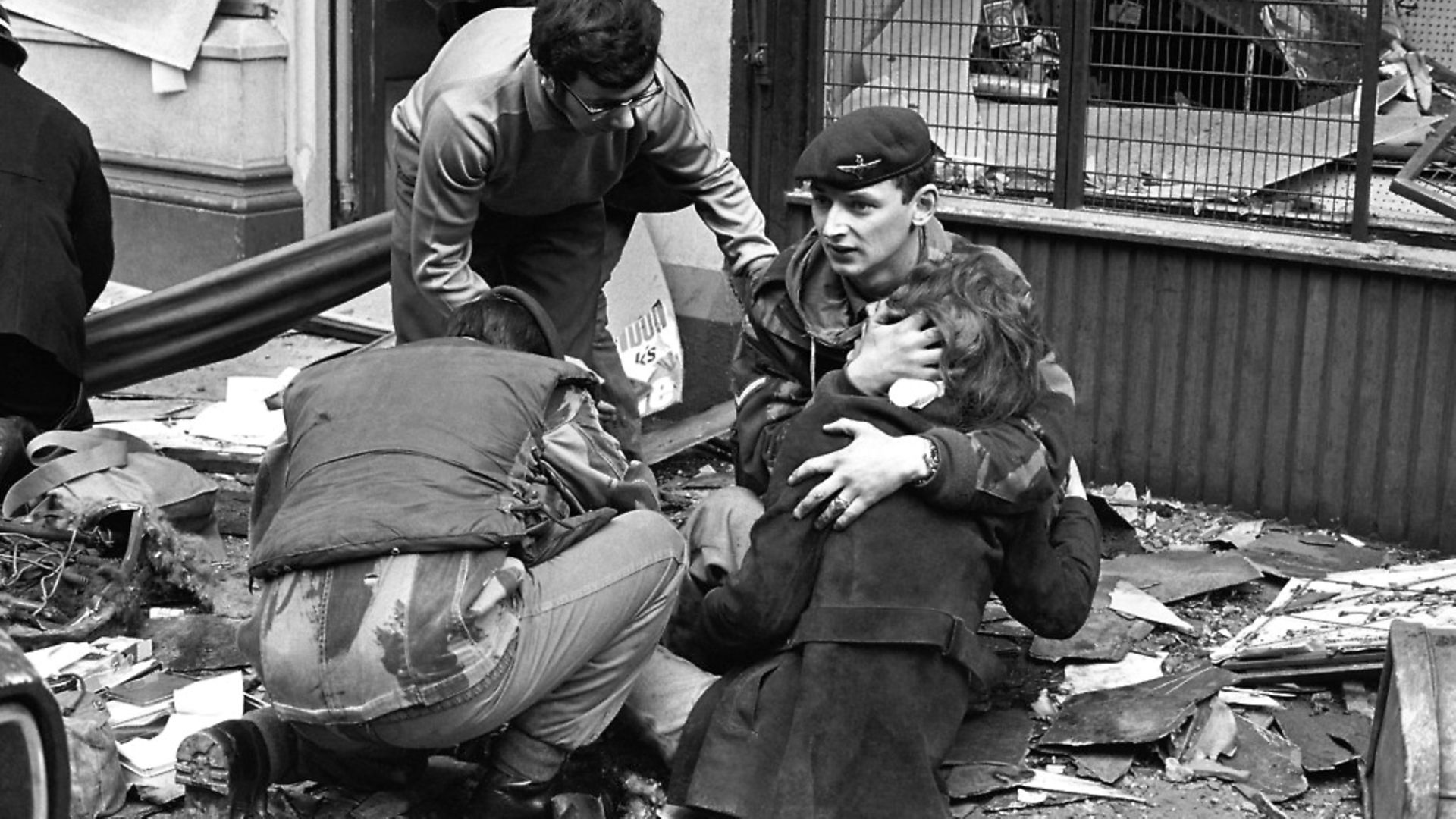 A British paratrooper takes a young girl in his arms to comfort her after she had been hurt in the bomb blast in Donegal Street, Belfast. - Credit: PA Archive/PA Images