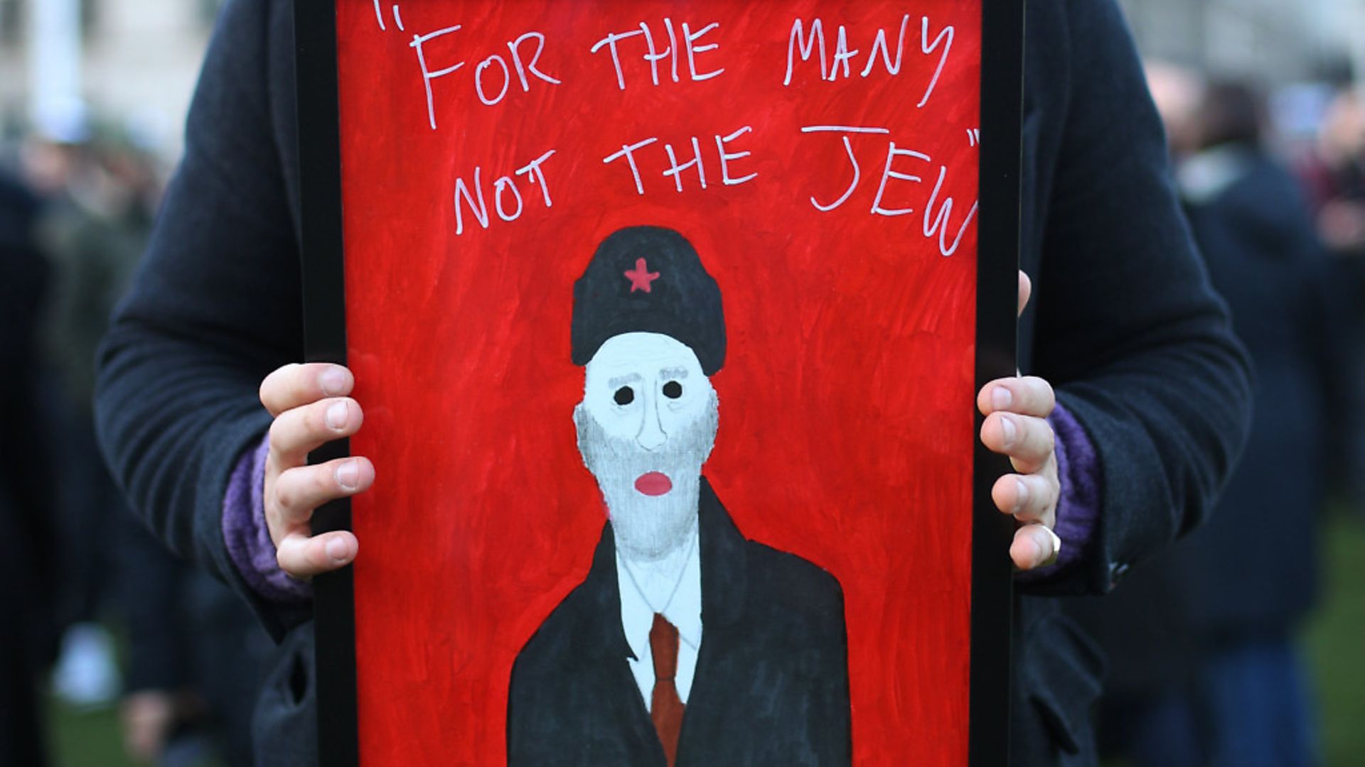 A demonstrator holding a painting saying"For the many not the Jew" as people protest against anti-Semitism in the Labour party in Parliament Square, London. Picture: Yuki Mok - Credit: PA Wire/PA Images