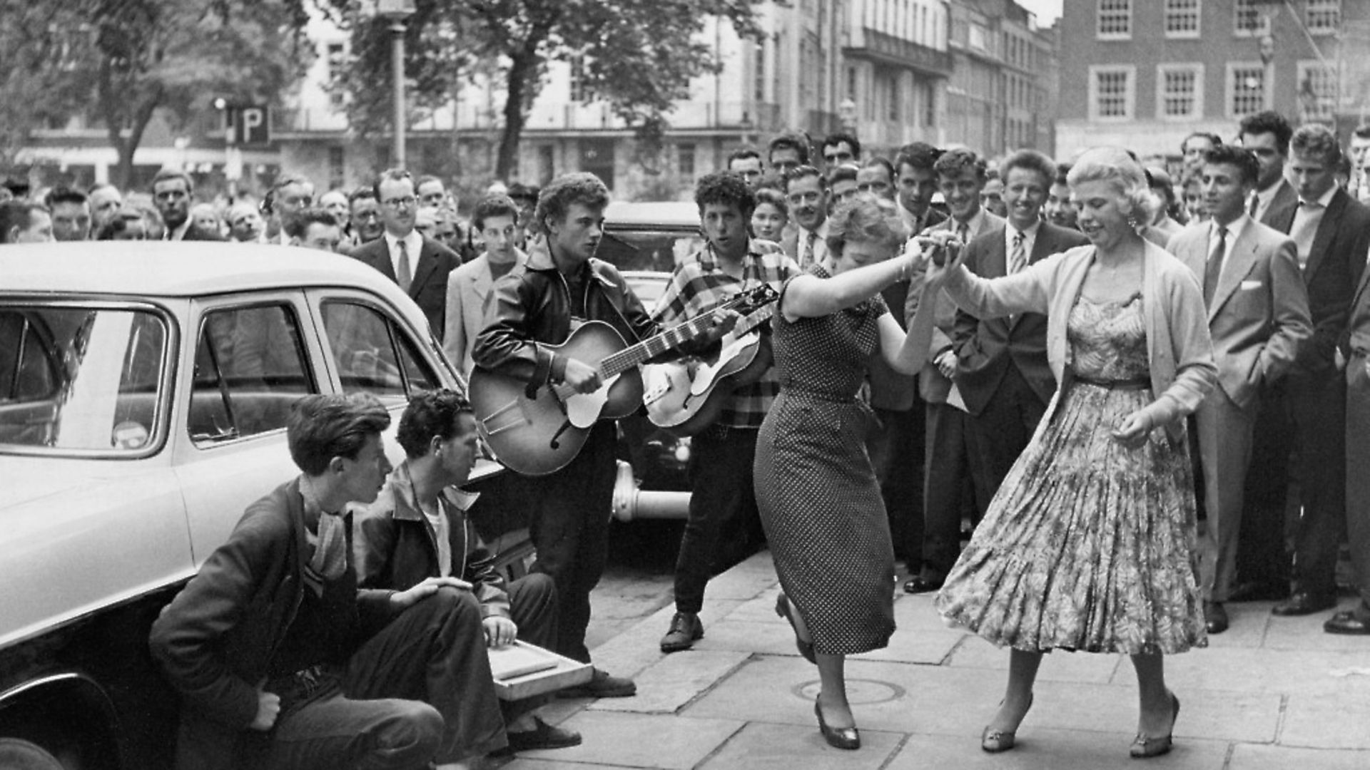A skiffle band draws a crowd in London's Soho Square. the skiffle movement peaked in 1957. Photo by Hulton-Deutsch/Hulton-Deutsch Collection/Corbis via Getty Images. - Credit: Corbis via Getty Images