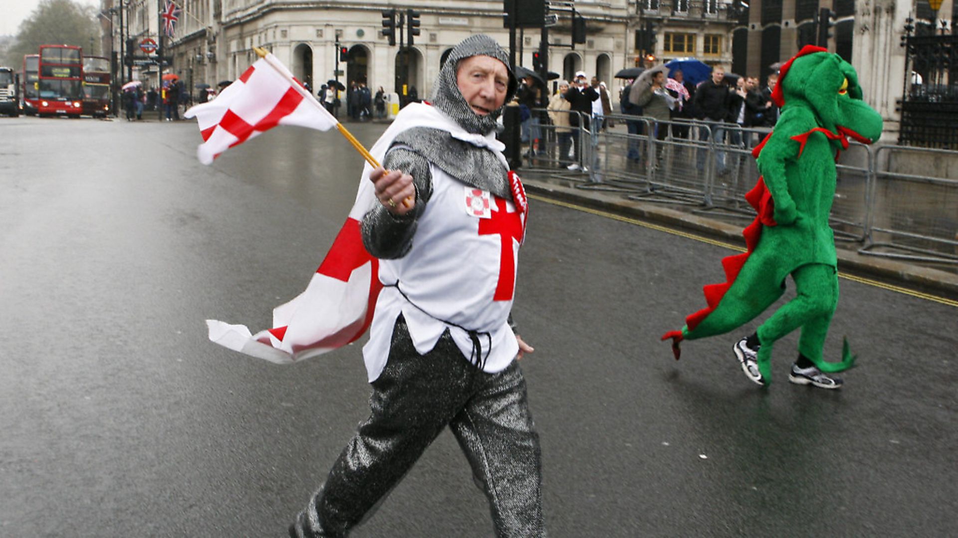 A man dressed as Saint George crosses the road beside a man dressed as a dragon outside the Houses of Parliament as part of a political protest by The English Democrats. (ADRIAN DENNIS/AFP/Getty Images) - Credit: AFP/Getty Images