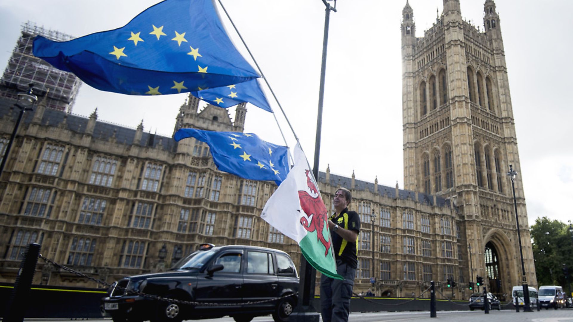 A man holds Welsh and European  flags outside the the Houses of Parliament. Photograph: Lauren Hurley/PA. - Credit: PA Archive/PA Images