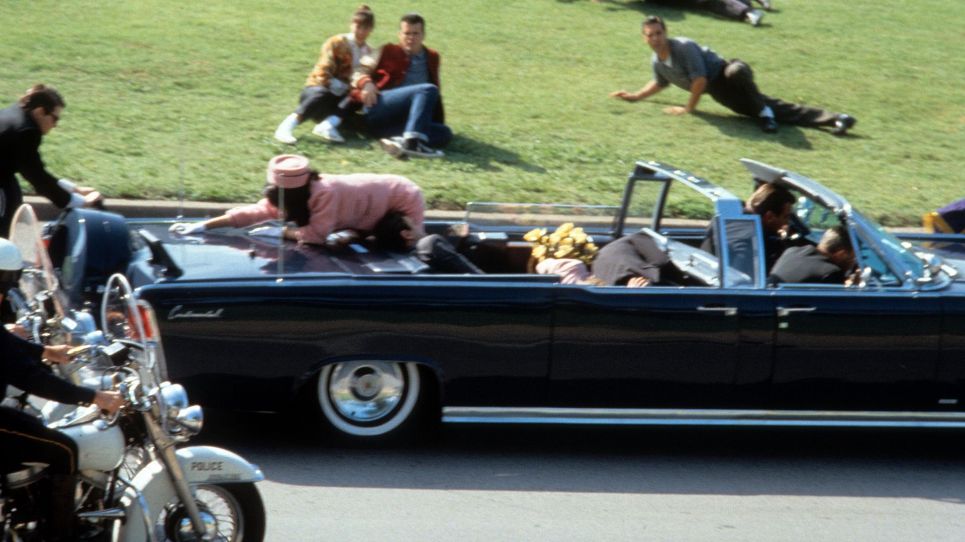 Jodie Farber reaches across the car in a scene from the film 'JFK', 1991. (Photo by Warner Brothers/Getty Images) - Credit: Getty Images