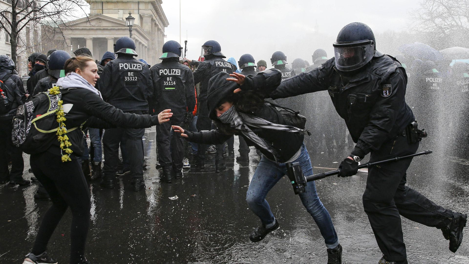 Police clash with a demonstrator near the German parliament, as water cannons are used to break up a protest against coronavirus restrictions - Credit: Anadolu Agency via Getty Images