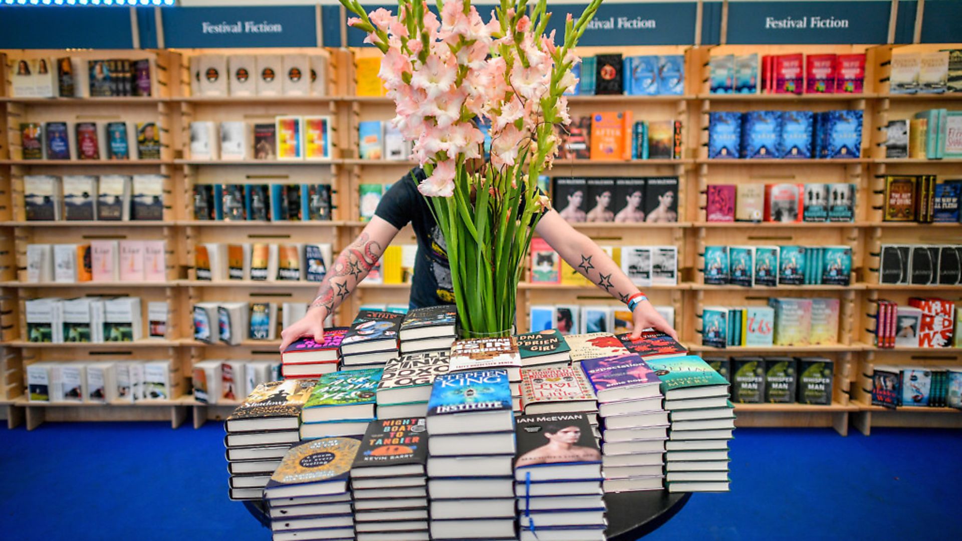 A worker organises and straightens books in a bookstore. Photograph: Ben Birchall/PA. - Credit: PA Wire/PA Images