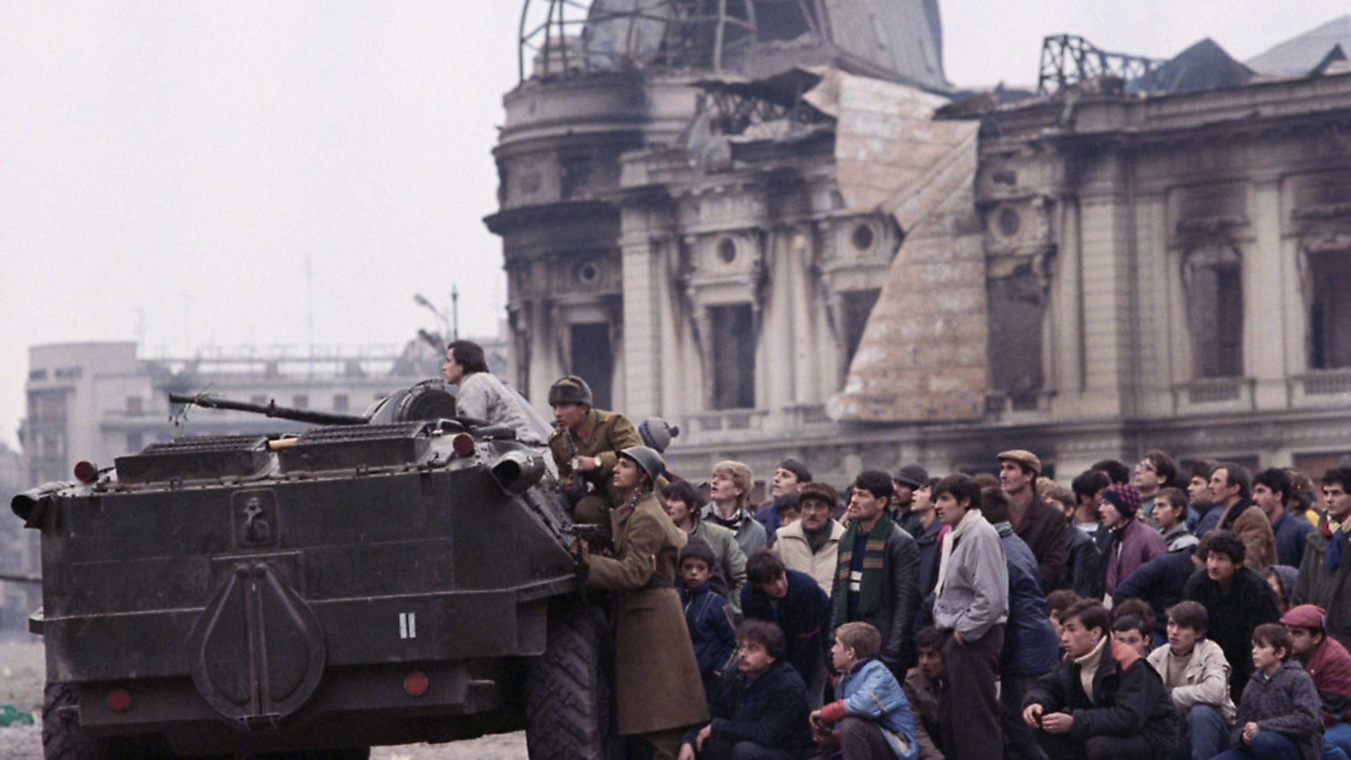 A crowd of civilians hide after the overthrow of Romanian dictator Nicolae Ceausescu. Photo: David Turnley/Corbis/VCG via Getty Images - Credit: Corbis/VCG via Getty Images