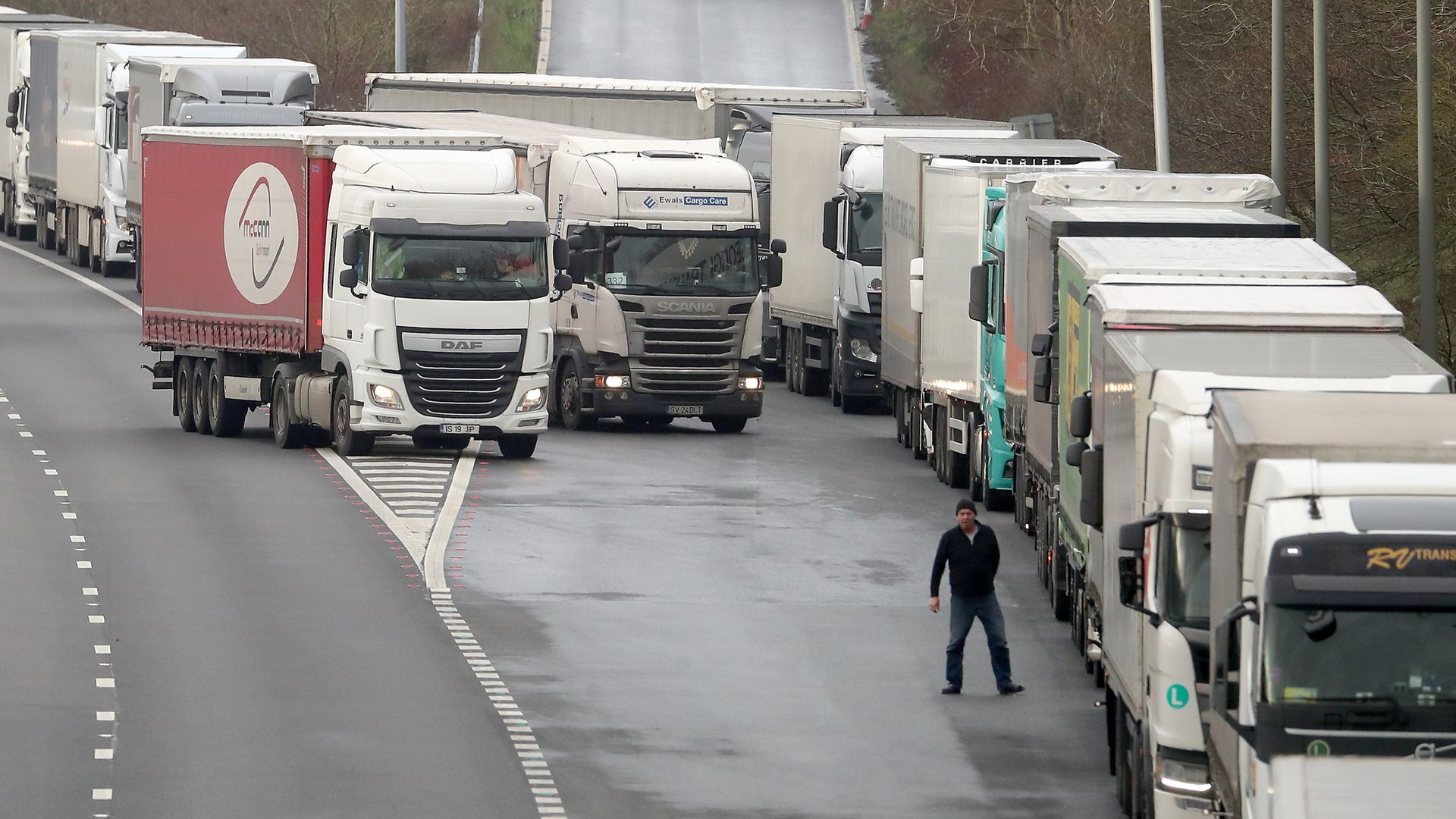 A lorry driver views the queue of lorries on the M20 as lorries wait to enter the Eurotunnel site in Folkestone, Kent, due to heavy freight traffic. - Credit: PA