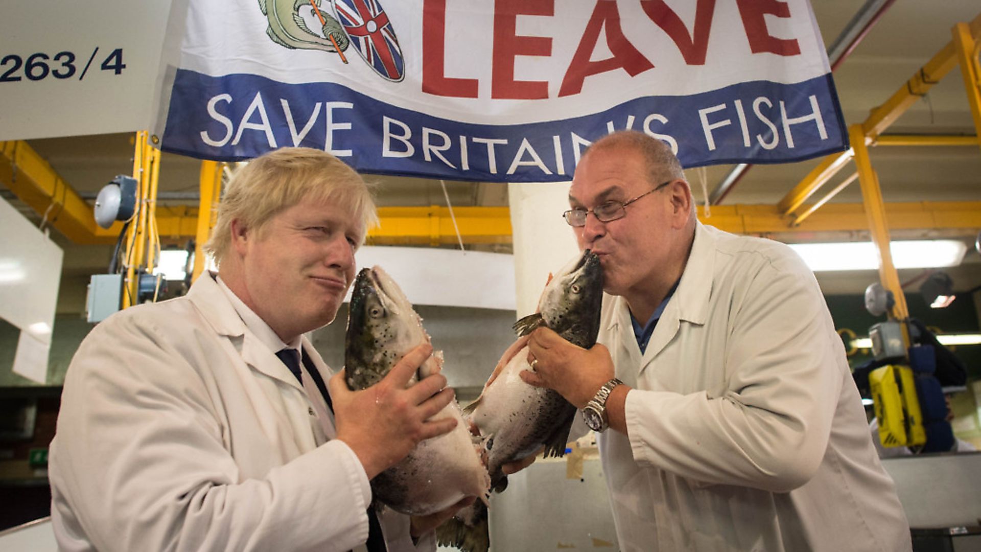 Boris Johnson (left) kisses a wild salmon as he is shown around Billingsgate Fish Market in London with porter Greg Essex. Photograph: Stefan Rousseau/PA. - Credit: PA Archive/PA Images