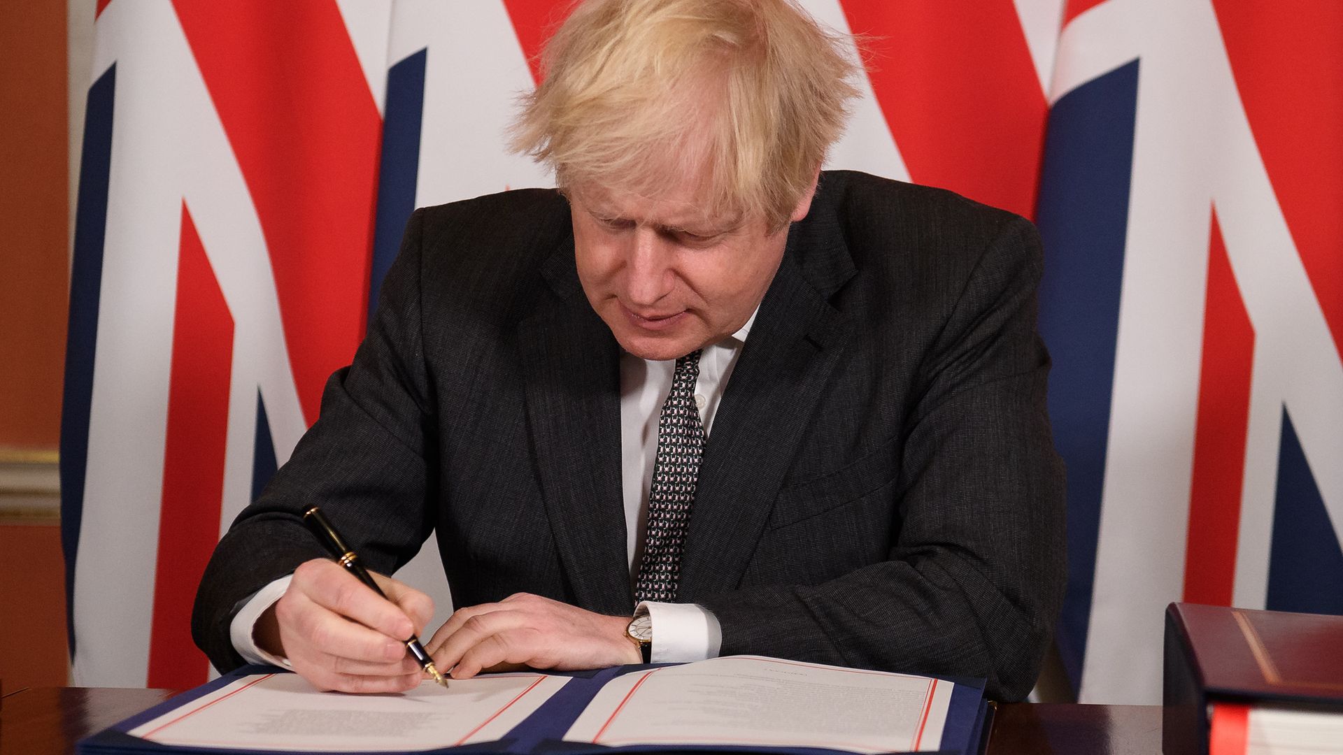 Prime Minister Boris Johnson signs the EU-UK Trade and Cooperation Agreement at 10 Downing Street, Westminster - Credit: PA