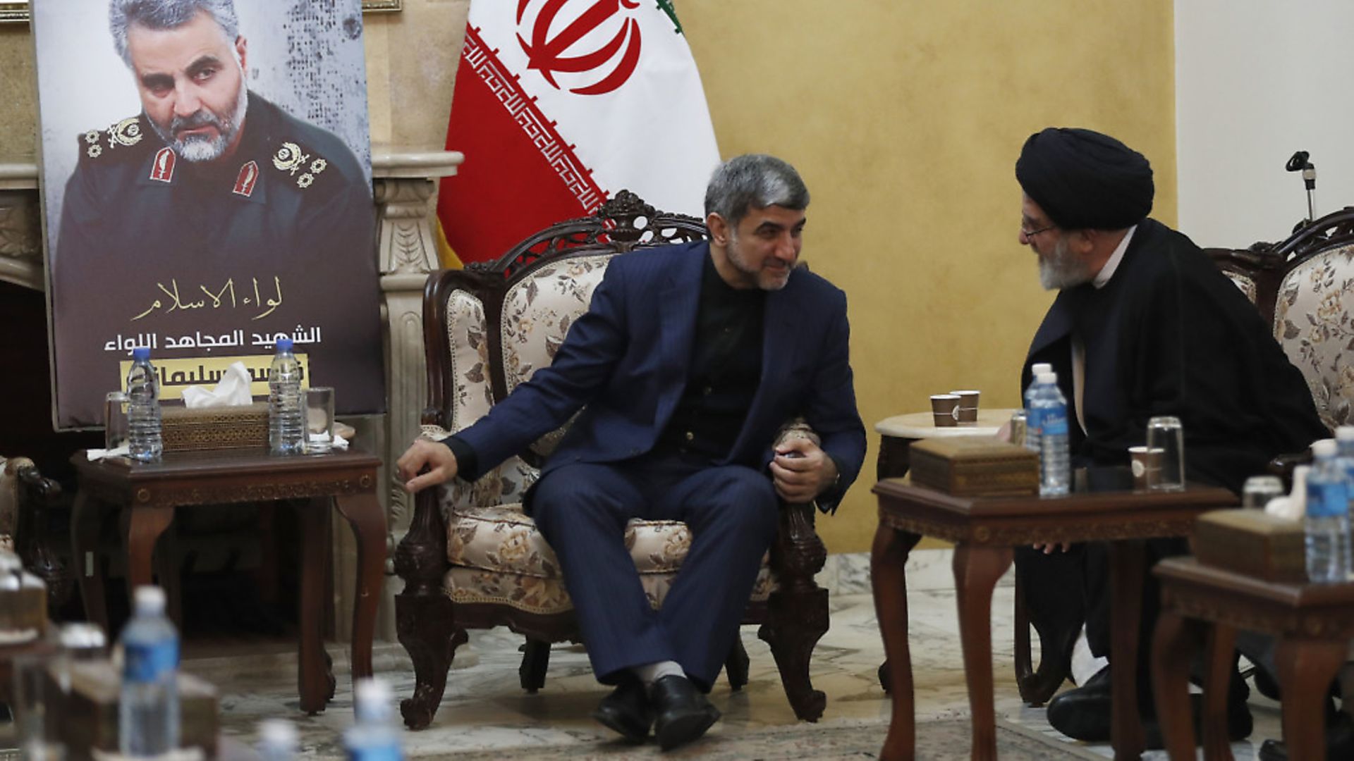 Iran's Ambassador to Lebanon Mohammed Jalal Feiruznia, left, receives condolences from Ibrahim Amin al-Sayyed, head of Hezbollah political bureau, right, as they sit next of a portrait of the Iranian Revolutionary Guard Gen. Qassem Soleimani, at the Iranian embassy, in Beirut. (AP Photo/Hussein Malla) - Credit: AP