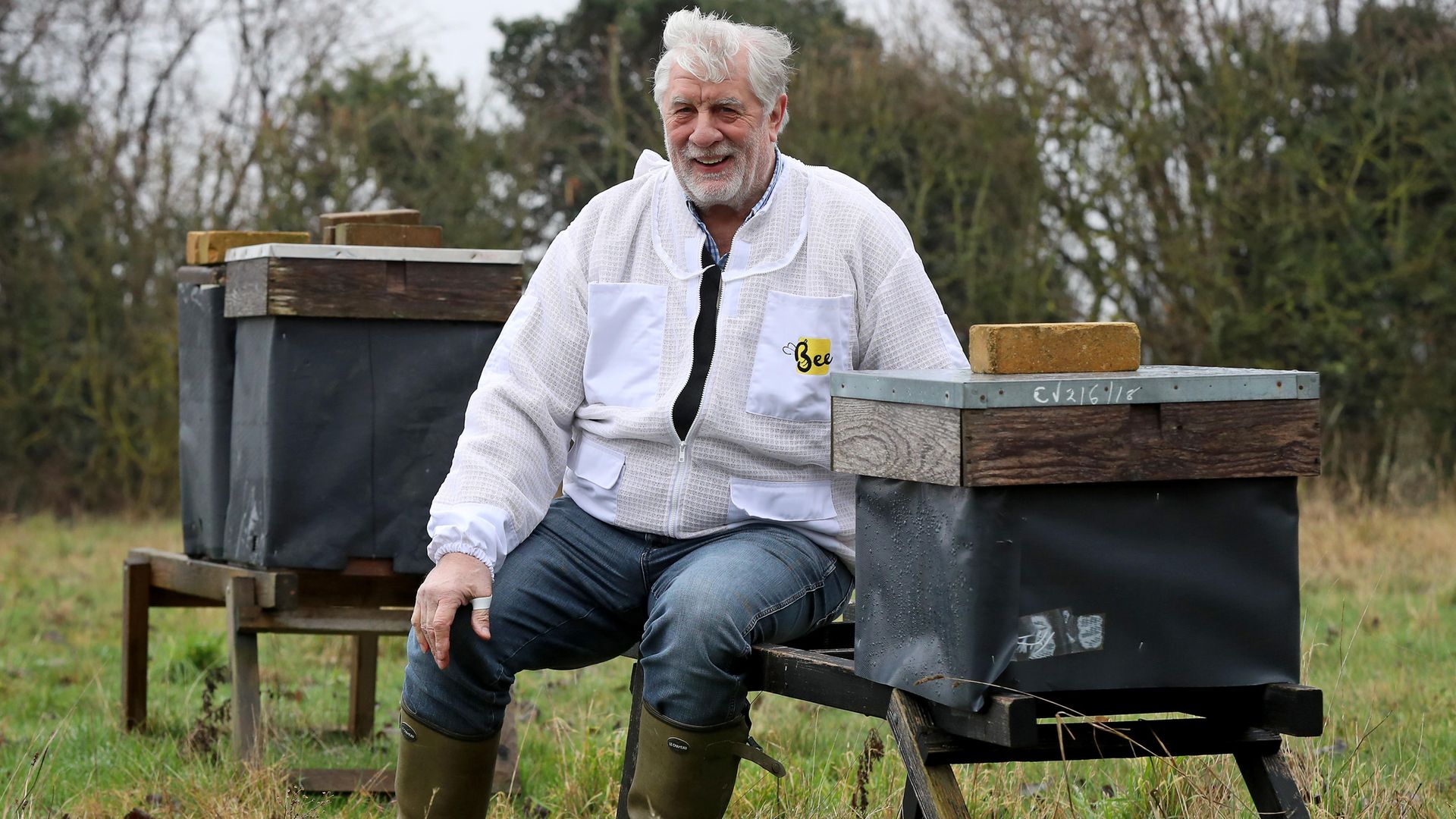 Beekeeper Patrick Murfet sits amongst some of his hives in an orchard near Canterbury in Kent, as he is told the 15 million bees he wants to bring into the UK for next spring may be seized and destroyed if he does - Credit: PA