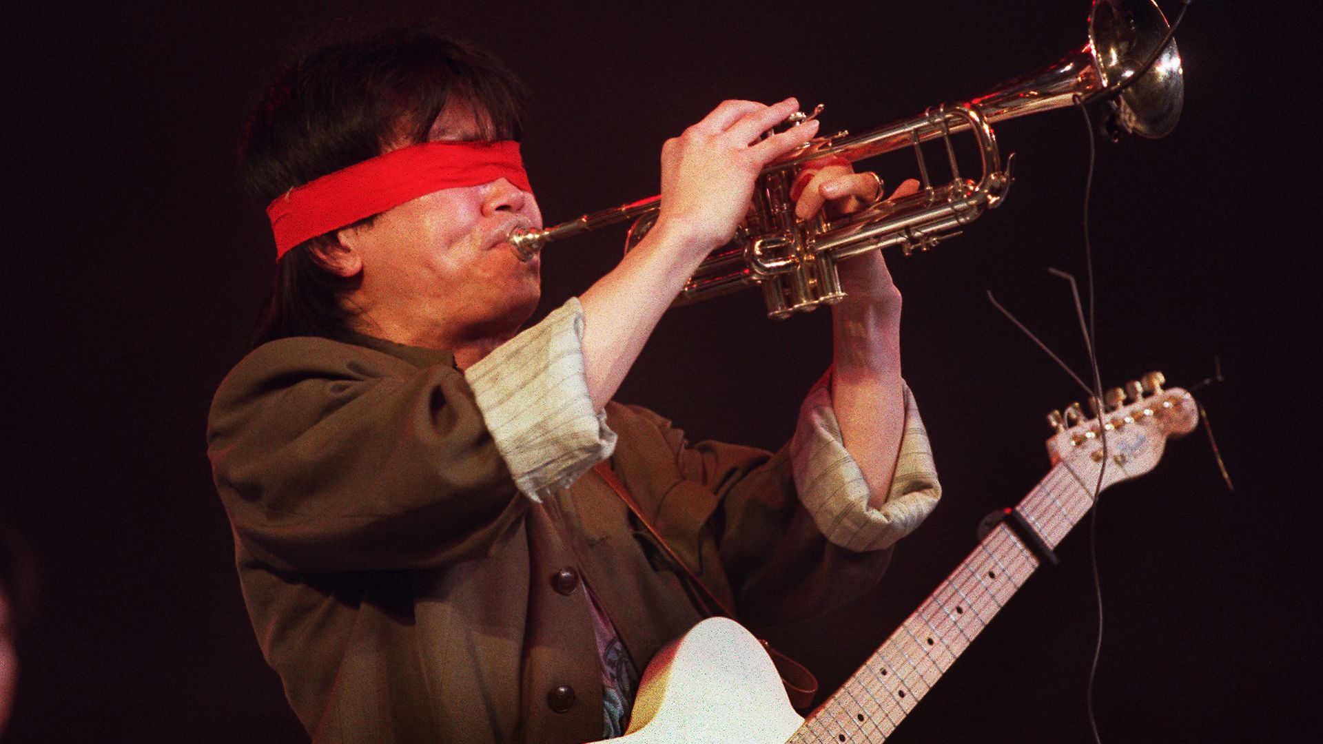 A blindfolded Cui Jian performs in Nanjing, in 1992. It was the rocker's first officially sanctioned appearance in two years. His politically-charged lyrics are frowned upon by authorities - Credit: AFP via Getty Images