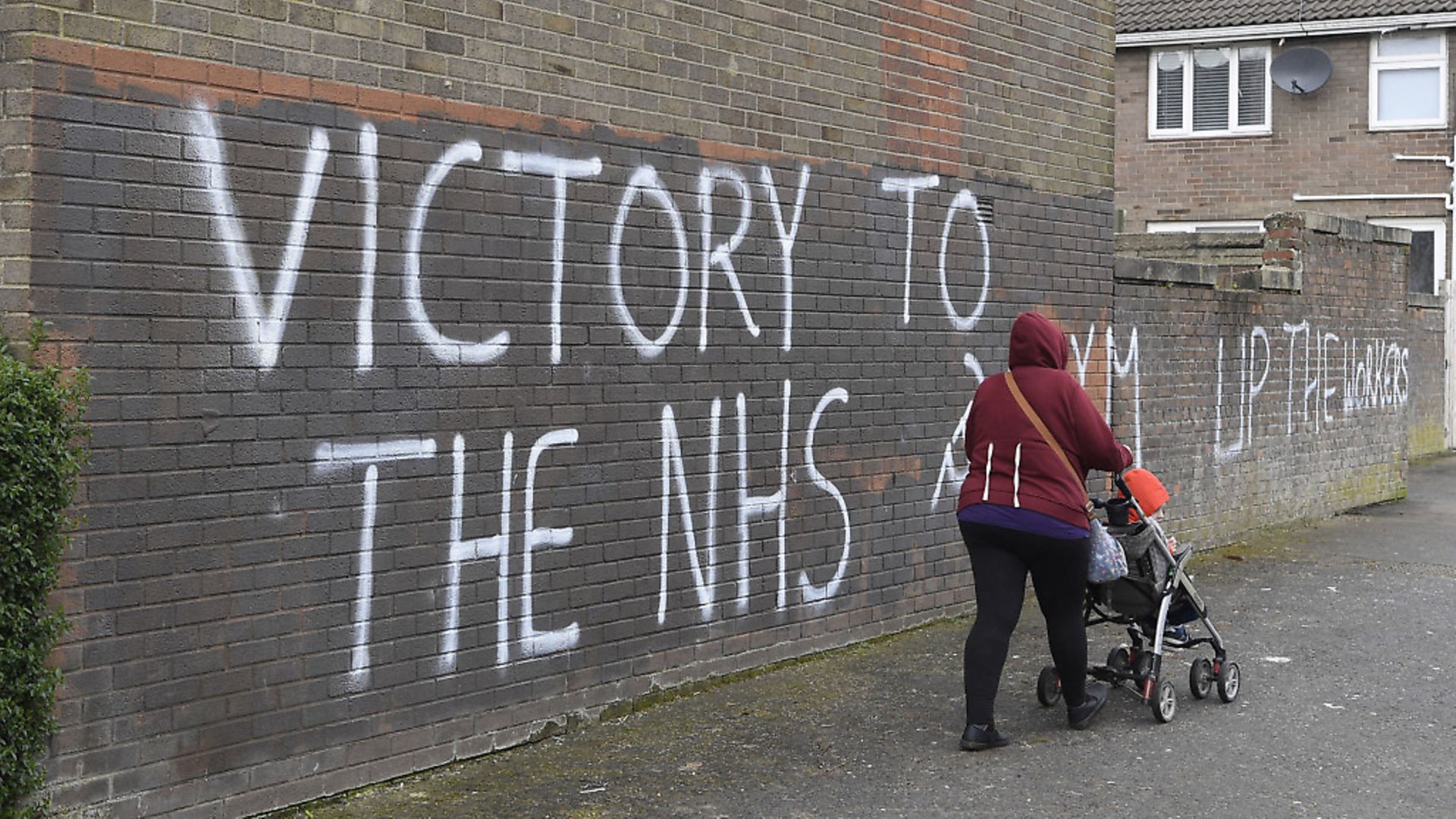 A woman walks past a message of support for the NHS in Londonderry, as the UK continues in lockdown to help curb the spread of the coronavirus. PA Photo. Picture date: Tuesday March 31, 2020. A total of 1,408 patients have died after testing positive for coronavirus in the UK as of 5pm on Sunday. See PA story HEALTH Coronavirus. Photo credit should read: Michael Cooper/PA Wire - Credit: PA