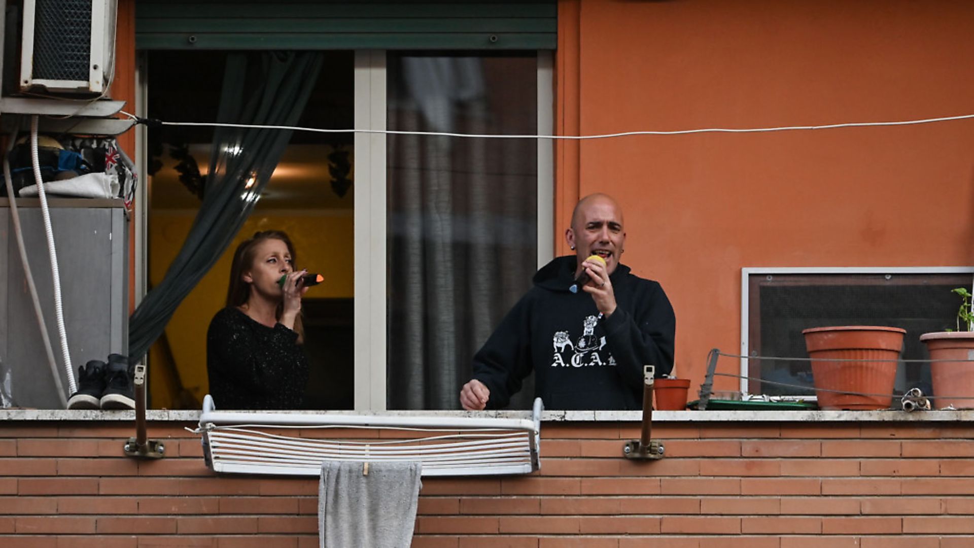 Italians join the flash mob call to perform "Una canzone per l'Italia" in the Magliana district of Rome, March 15. Picture: Getty Images - Credit: AFP via Getty Images