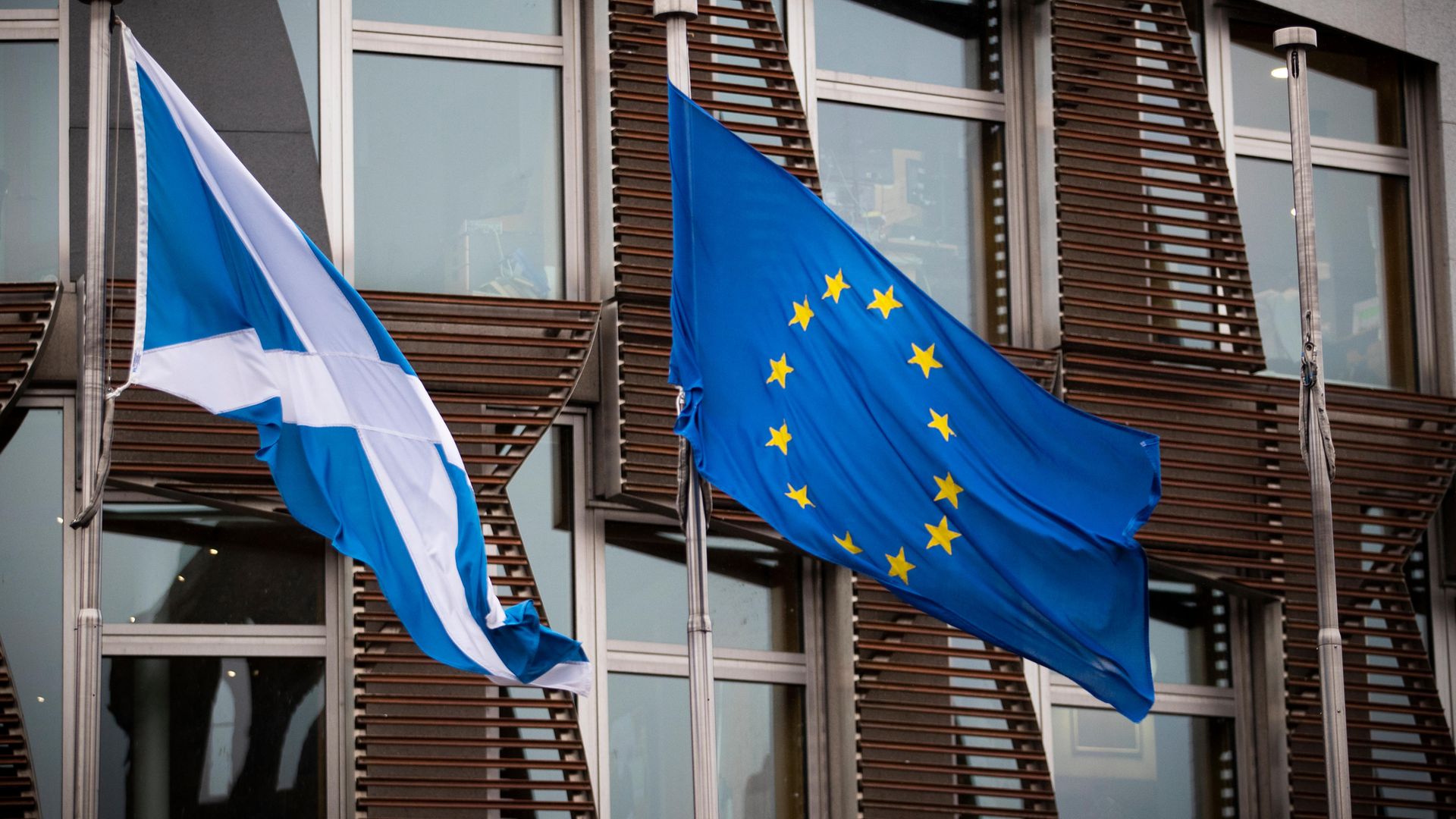 The Saltire and EU flag fly outside the Scottish Parliament in Edinburgh - Credit: PA