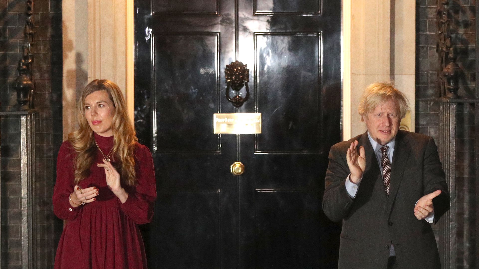 Prime minister Boris Johnson and his partner Carrie Symonds outside 10 Downing Street, London, join in with a nationwide clap in honour of Captain Sir Tom Moore - Credit: PA