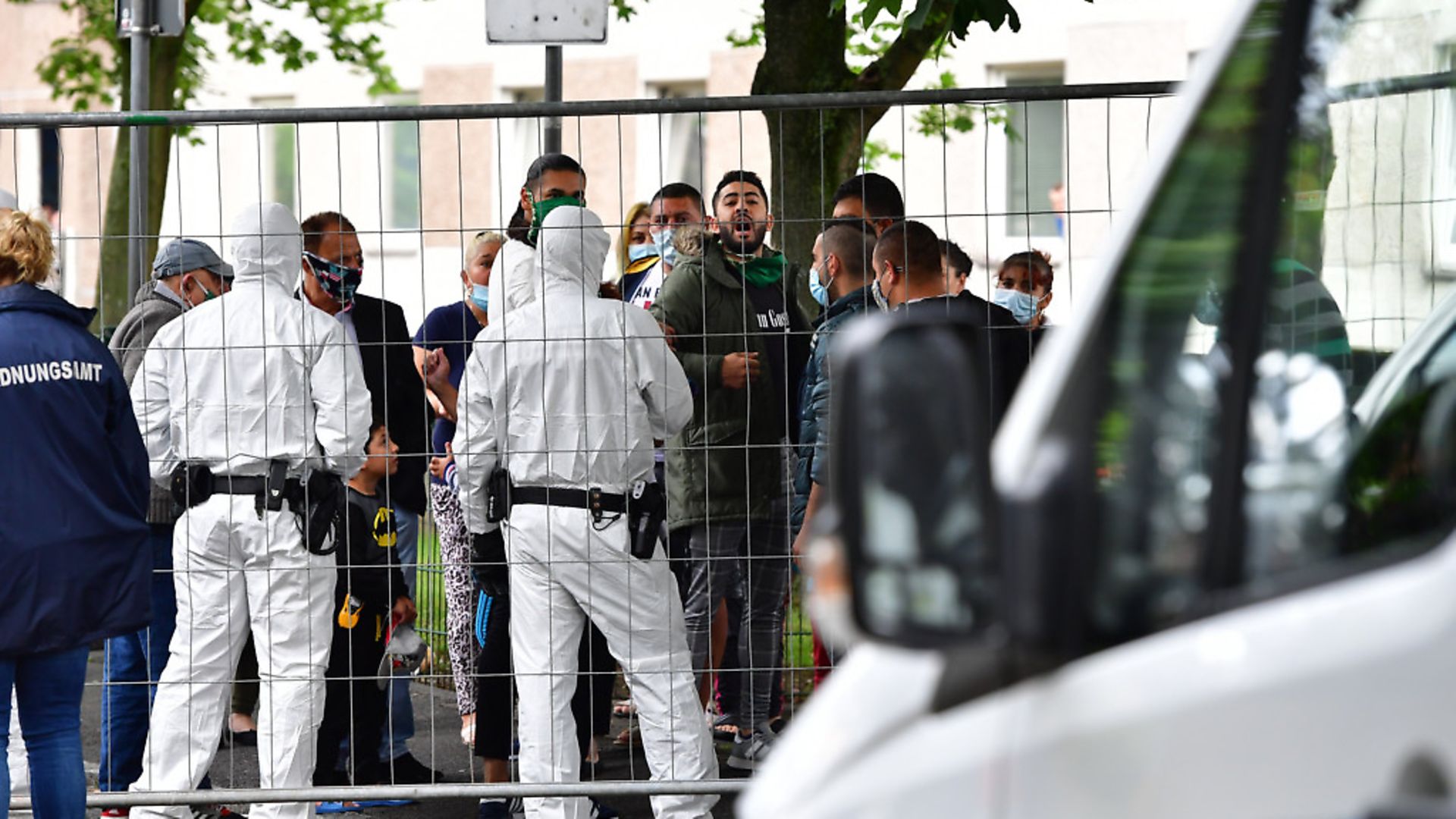 GOETTINGEN, GERMANY - JUNE 19: Police forces wearing full protective suits prepare to enter the high-rise apartment building, as tensions between residents and authorities rise, struck by a coronavirus outbreak on June 19, 2020 in Goettingen, Germany. So far over 100 people have tested positive among the building's 700 residents. The outbreak comes on the heels on another outbreak in the similarly large Iduna apartment complex following celebrations to mark the end of Ramadan. (Photo by Alexander Koerner/Getty Images) - Credit: Getty Images