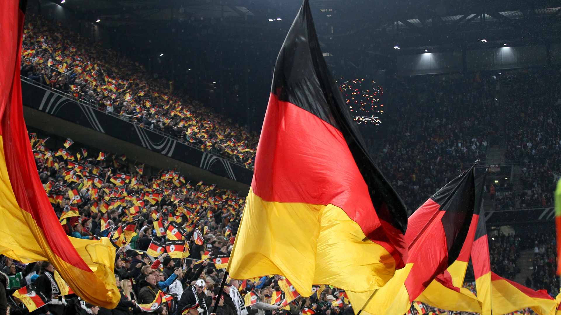 A German flag is flown in a sports stadium - Credit: PA