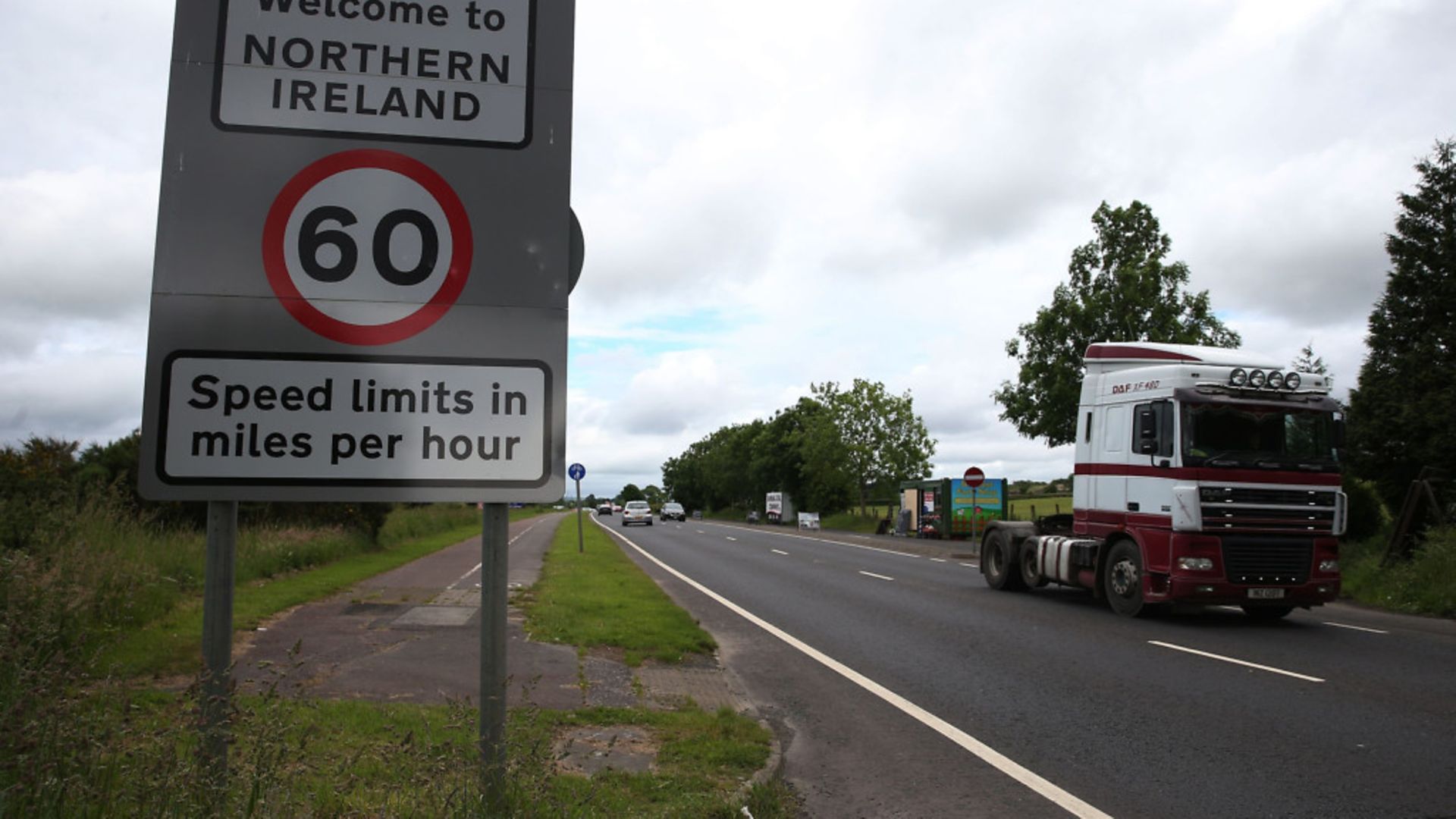 Traffic crossing the border between the Republic of Ireland and Northern Ireland in the village of Bridgend, Co Donegal - Credit: PA Wire/PA Images