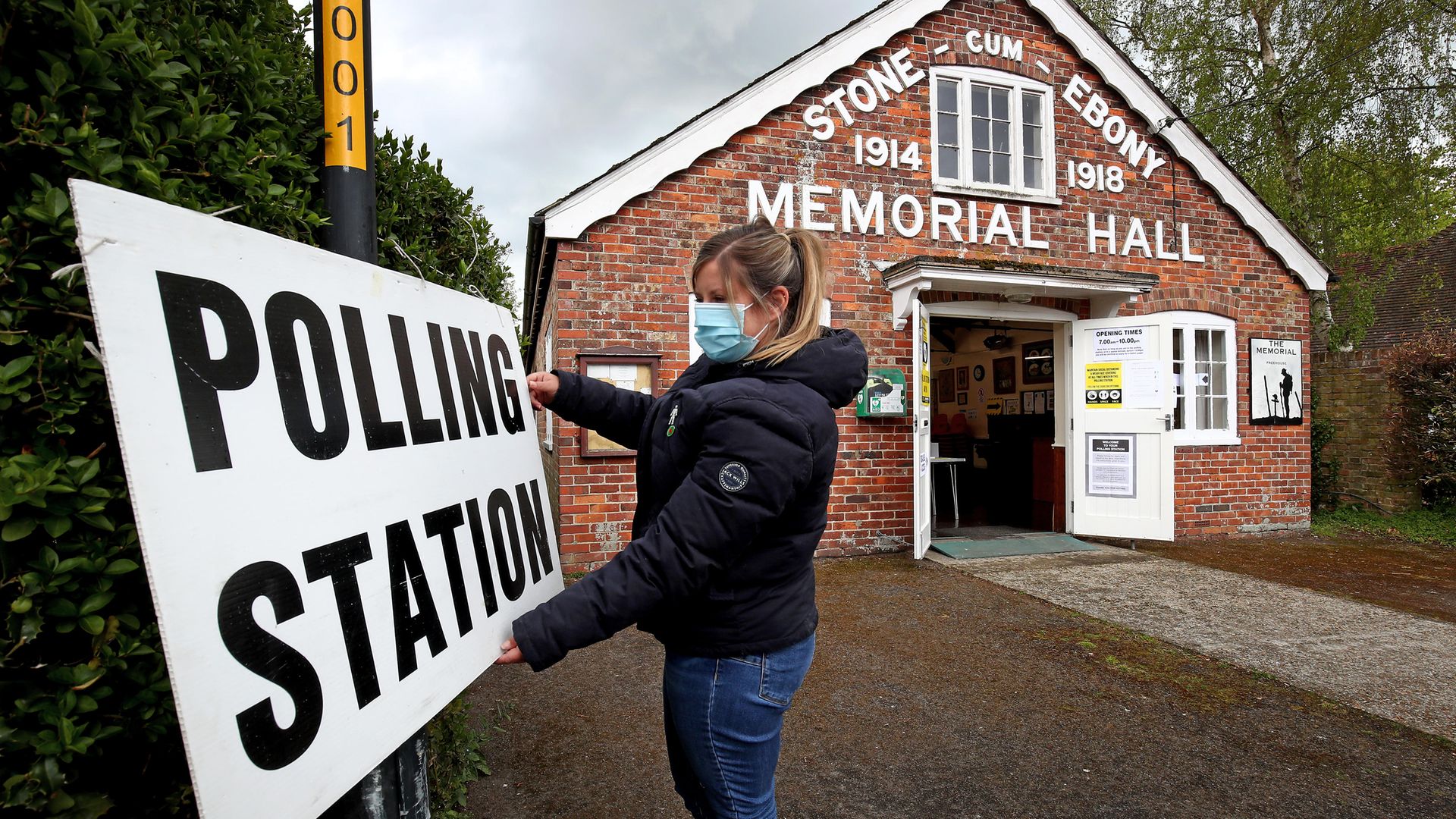 A poll clerk adjusts the sign outside a polling station - Credit: PA