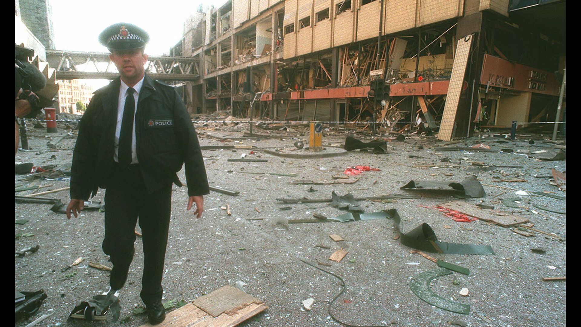 A police officer amid the damage caused by the IRA bomb in Manchester city centre - Credit: Sygma via Getty Images