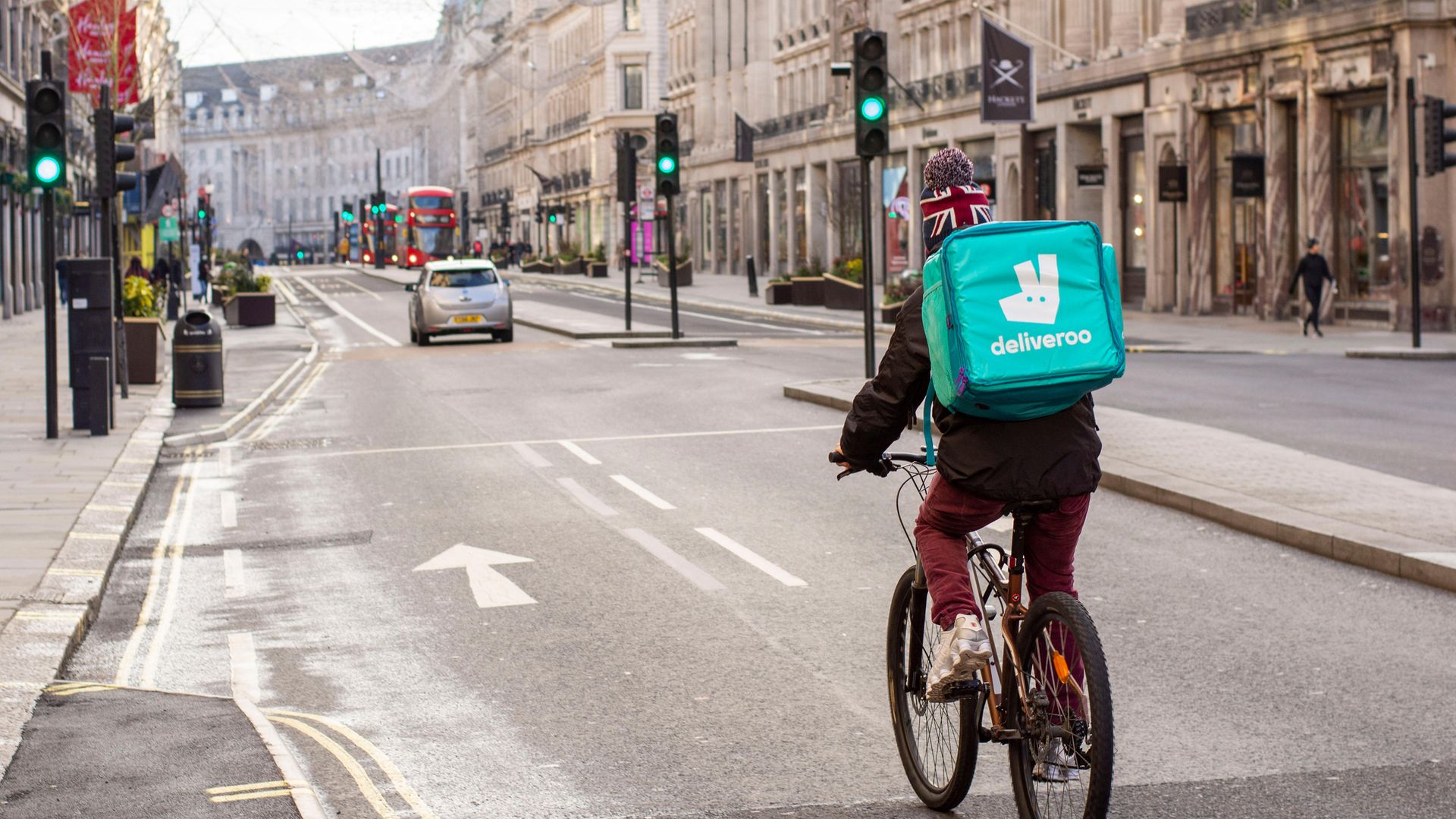 A Deliveroo courier rides along London's empty Regent Street during the Covid-19 lockdown - Credit: Photo by Pietro Recchia/SOPA Images/LightRocket via Getty Images