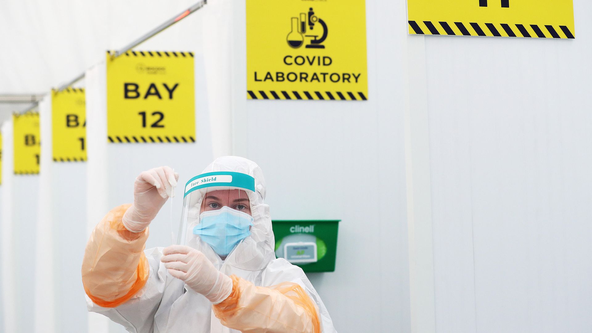 A lab technician with a swab at a testing facility at Dublin Airport - Credit: PA