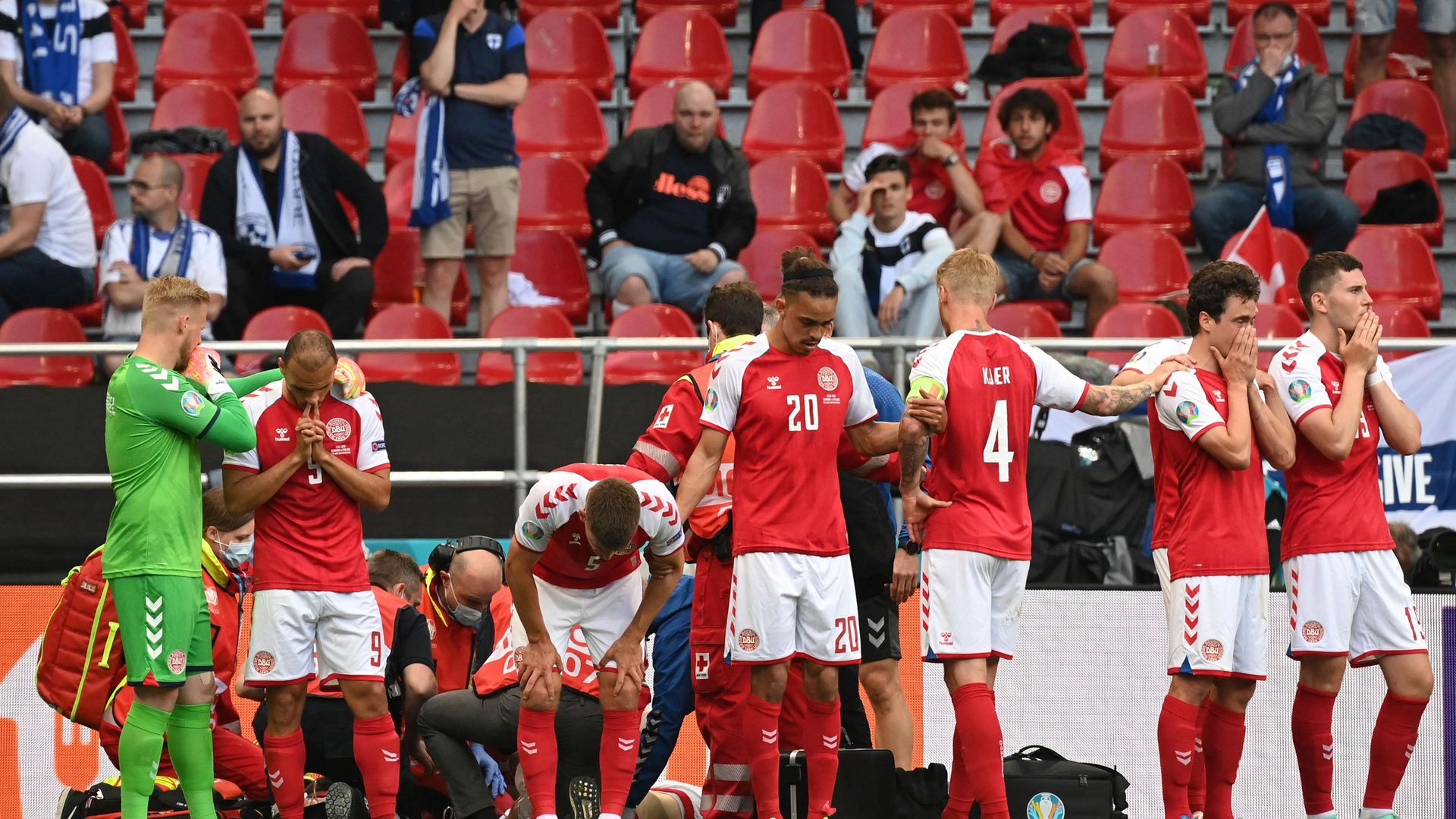 Shocked Denmark players gather around teammate Christian Eriksen after his collapse in the Euro 2020 match against Finland - Credit: Photo by JONATHAN NACKSTRAND/AFP via Getty Images