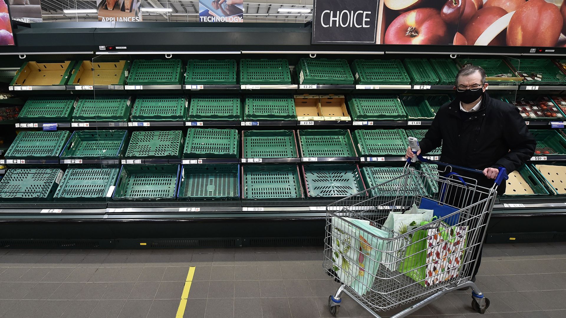 A supermarket shopper walks past rows of empty shelves in Tescos on January 14, 2021 in Belfast, Northern Ireland. Shortages and higher prices could soon be seen on the mainland - Credit: Photo by Charles McQuillan/Getty Images