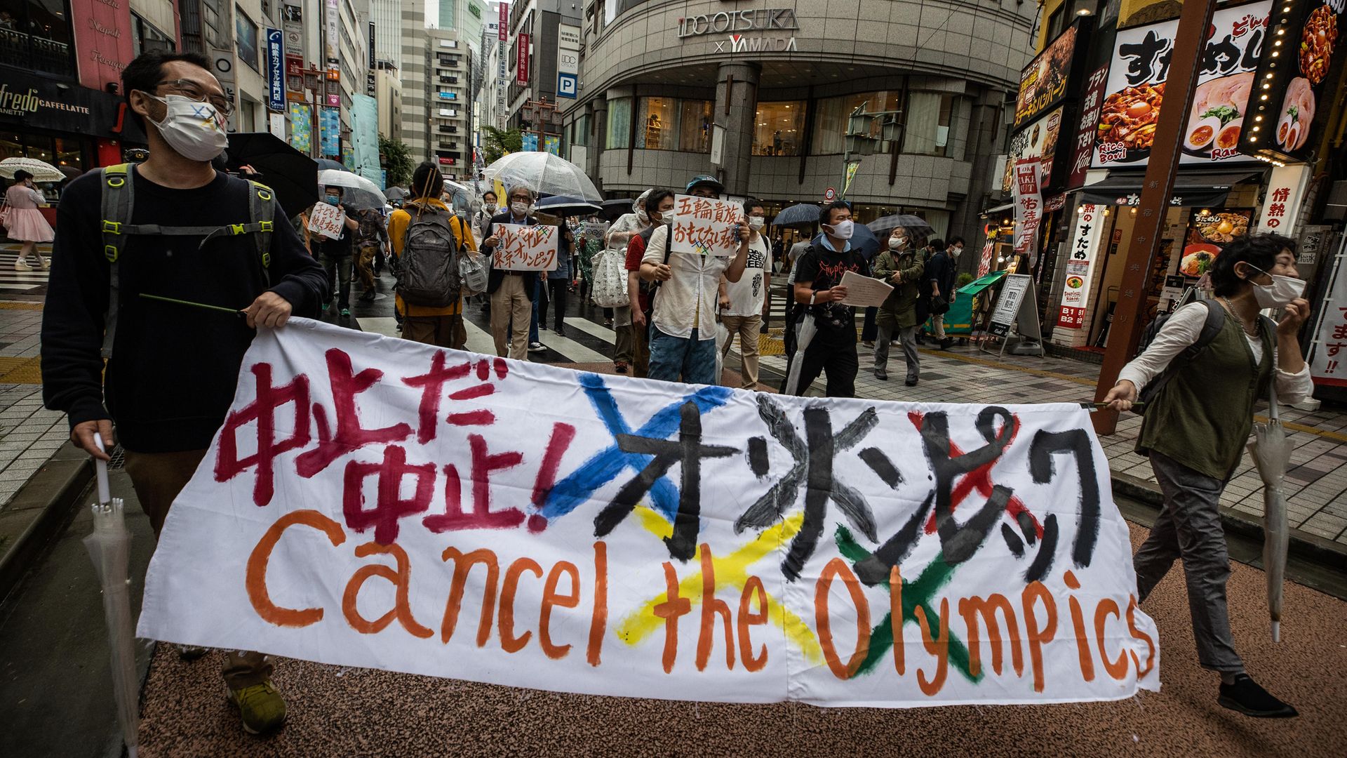 Protesters march through Shinjuku during a rally against the Tokyo 2020 Olympic Games on June 19, 2021 - Credit: Photo by Takashi Aoyama/Getty Images