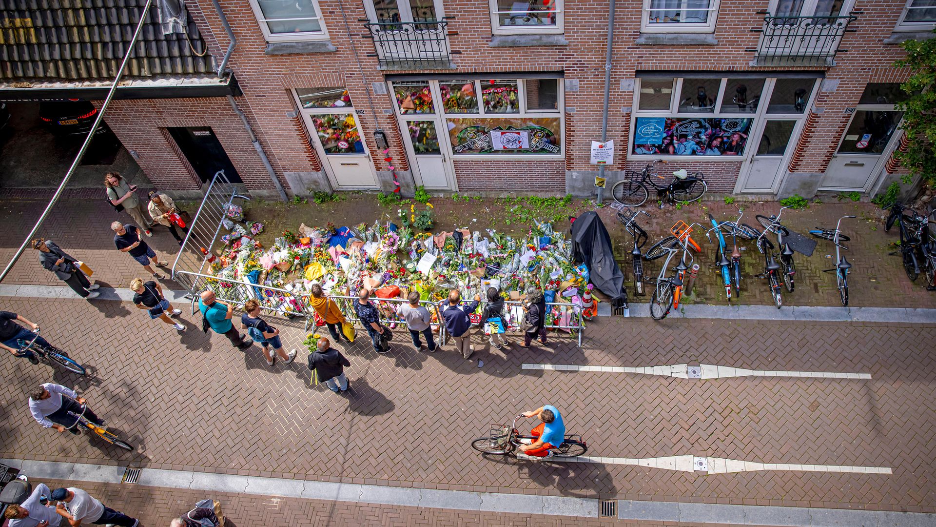 People lay flowers at the place in Amsterdam's Lange Leidsedwarsstraat, where crime reporter Peter R De Vries was shot - Credit: Getty Images