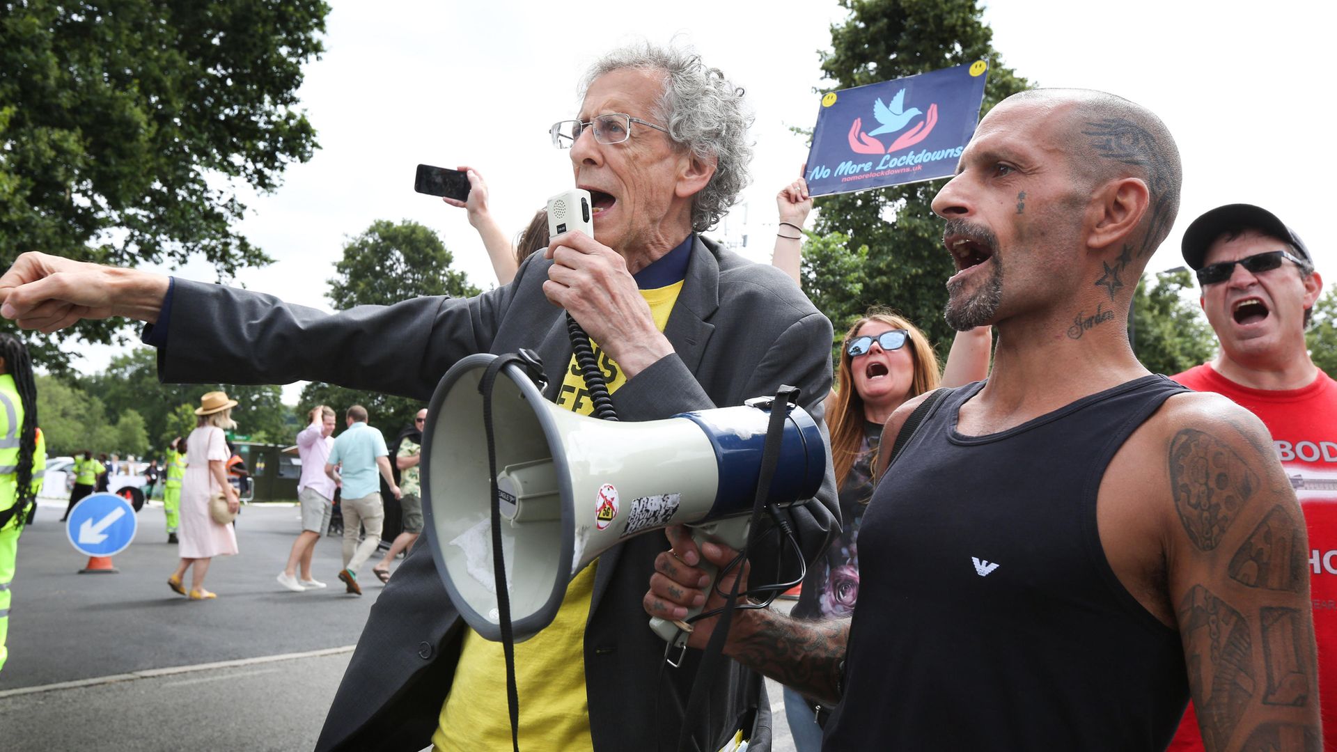 Anti-vaccine protestor Piers Corbyn speaks through a megaphone outside Centre Court on Wimbledon's Men's Finals Day - Credit: Photo by Martin Pope/SOPA Images/LightRocket via Getty Images